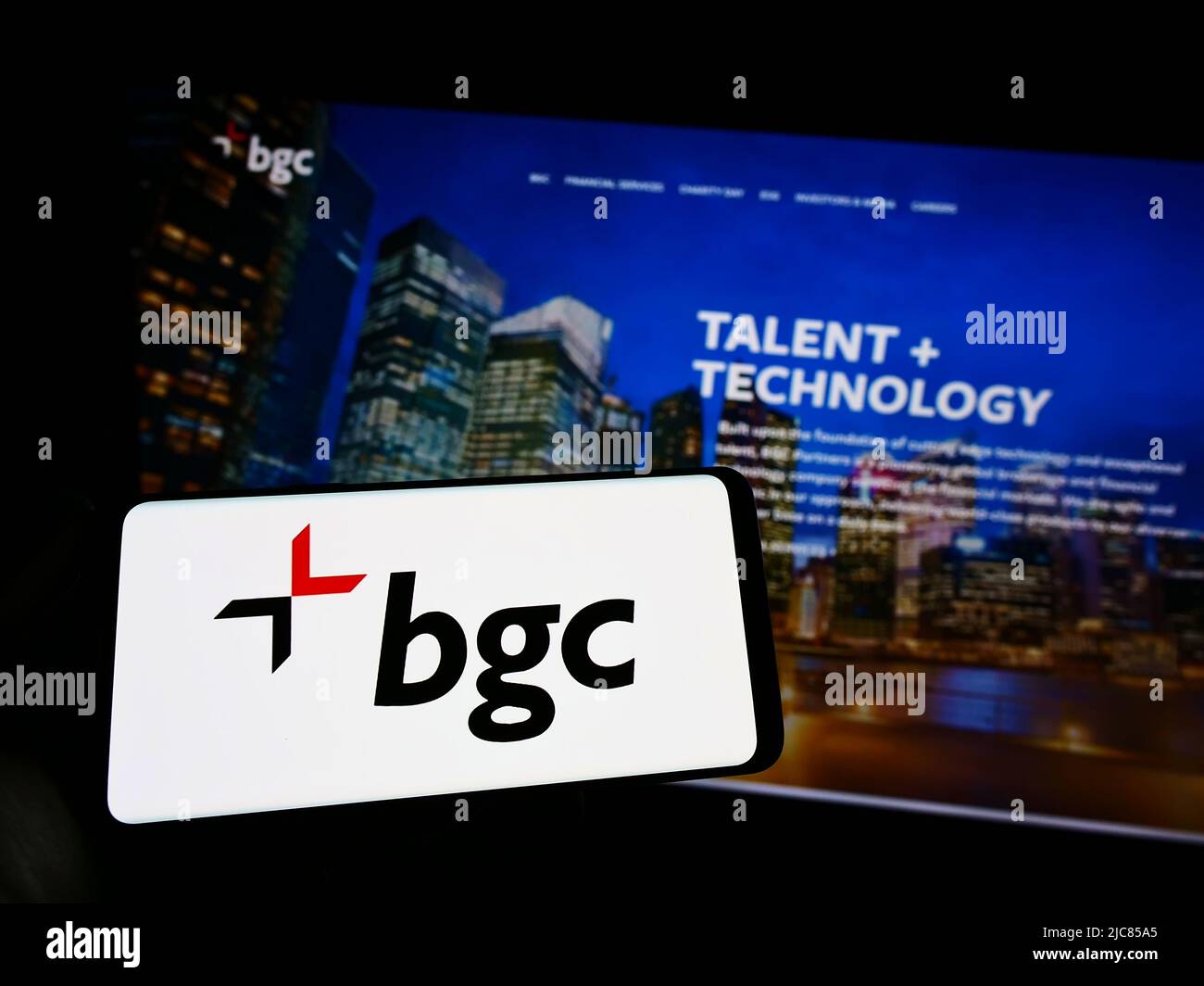 Persona che tiene uno smartphone con il logo della società di servizi finanziari degli Stati Uniti BGC Partners Inc. Sullo schermo di fronte al sito Web. Mettere a fuoco sul display del telefono. Foto Stock