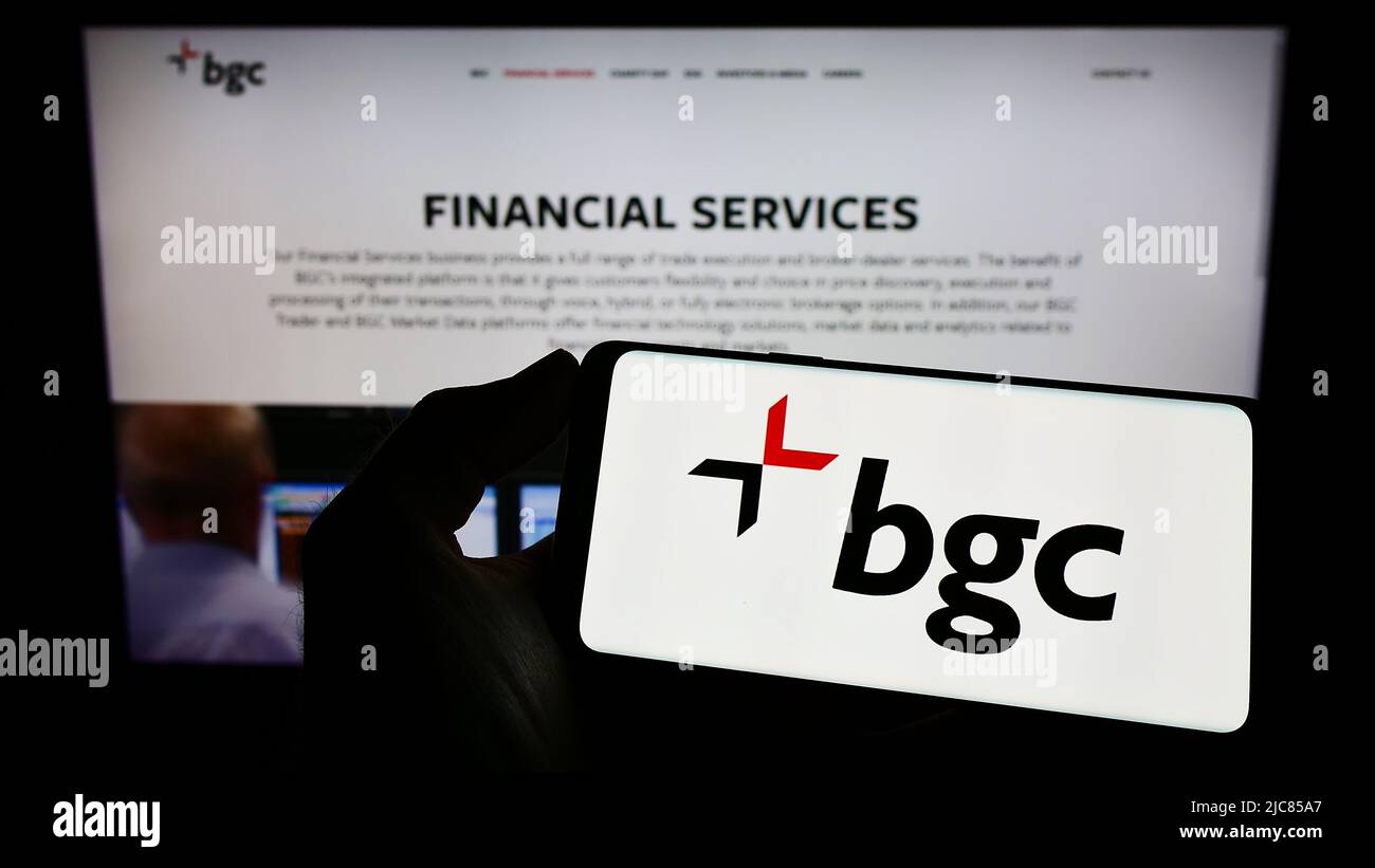 Persona che detiene il telefono cellulare con il logo della società di servizi finanziari degli Stati Uniti BGC Partners Inc. Sullo schermo di fronte alla pagina Web. Mettere a fuoco sul display del telefono. Foto Stock