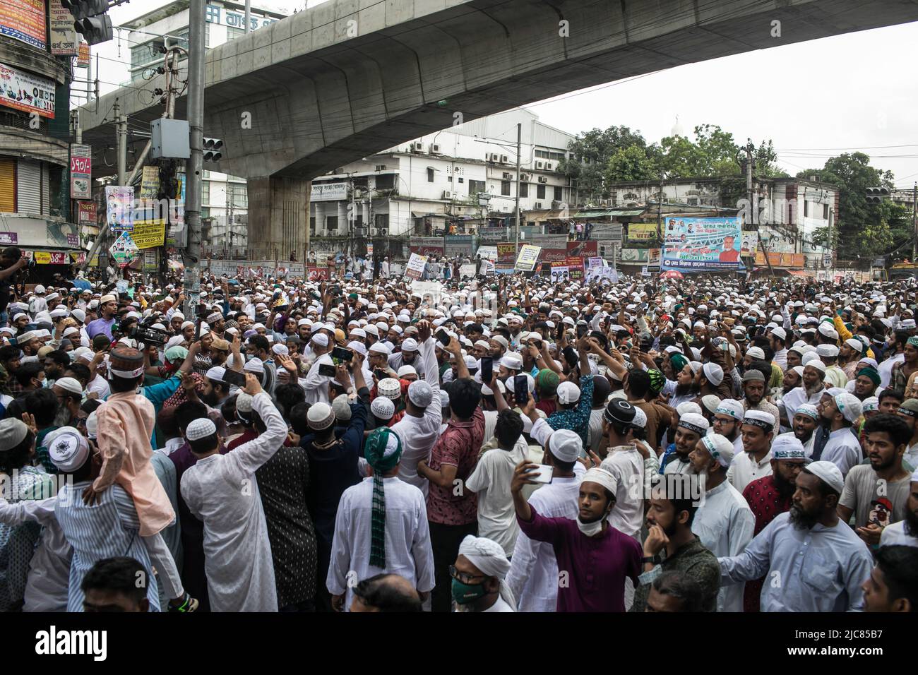 Dhaka, Bangladesh. 10th giugno 2022. Folle di devoti musulmani cantano slogan e tengono cartelli che esprimono la loro opinione durante la protesta. Migliaia di devoti musulmani del Bangladesh hanno preso per le strade vicino alla principale Moschea di Baitul Mukarram nel centro di Dhaka dopo le preghiere di venerdì contro gli insulti compiuti sul profeta Muhammad dal leader del BJP, Narendra modi. Credit: SOPA Images Limited/Alamy Live News Foto Stock