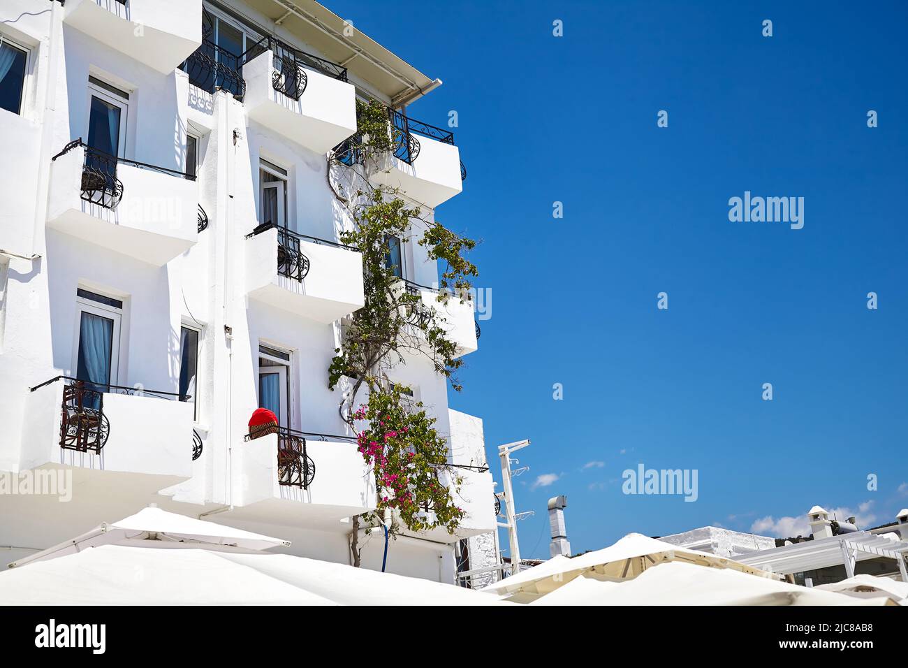 Piccolo hotel con balcone con sedia e decorazione floreale sulla strada di Bodrum, Turchia Foto Stock