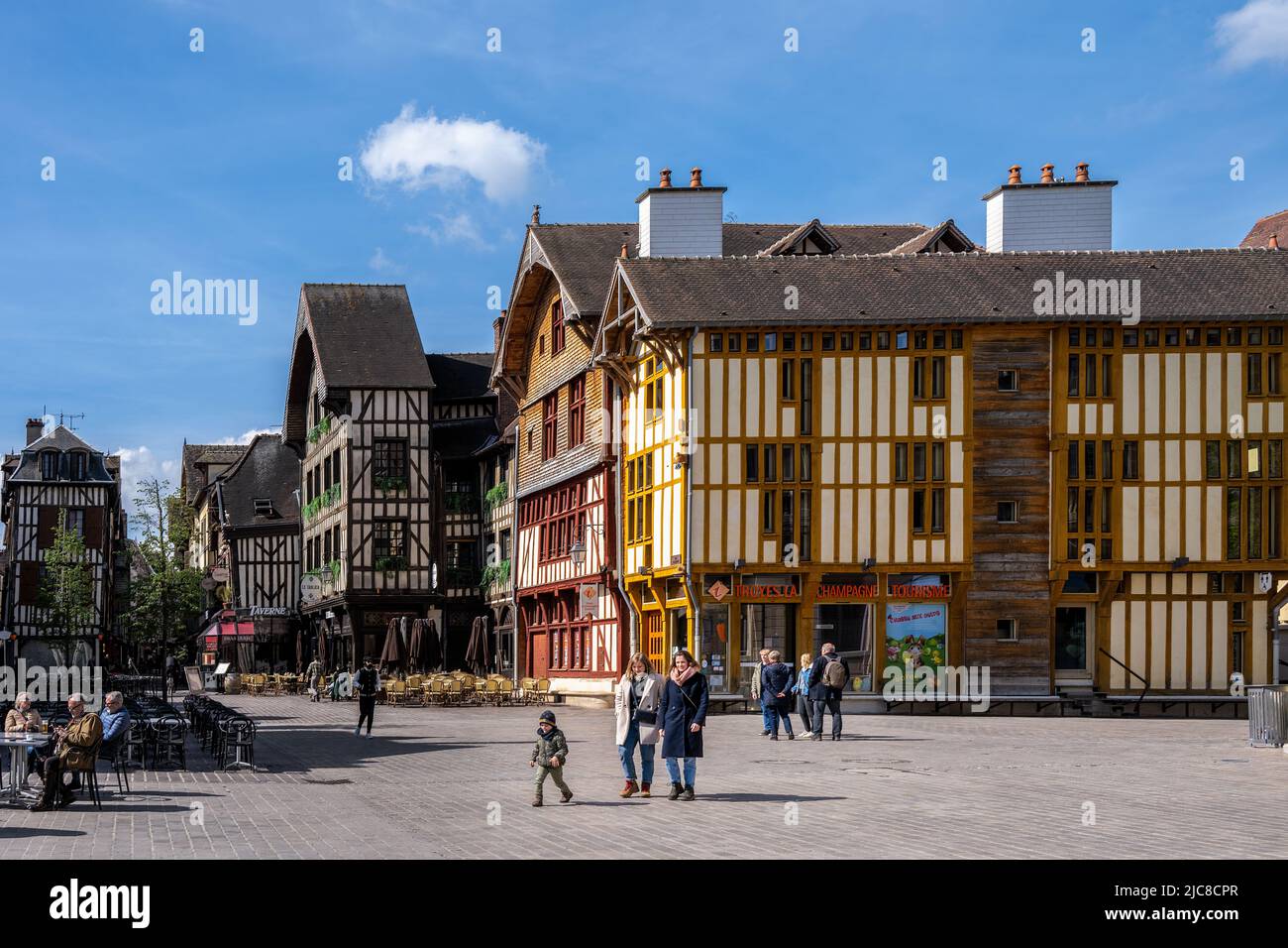 TROYES, FRANCIA - 10th APRILE 2022: Persone a piedi e godere delle terrazze caffè sulla Place Alexandre Israele con il suo bel mezzo legno medievale Foto Stock