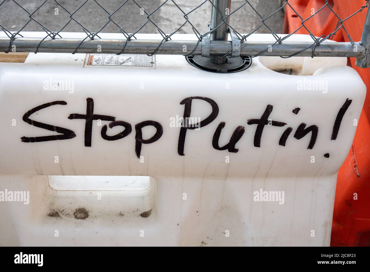 Fermare Putin! Testo scritto a mano sulla barriera di plastica bianca nel Meat Packing District di Manhattan, New York City, Stati Uniti d'America. Foto Stock