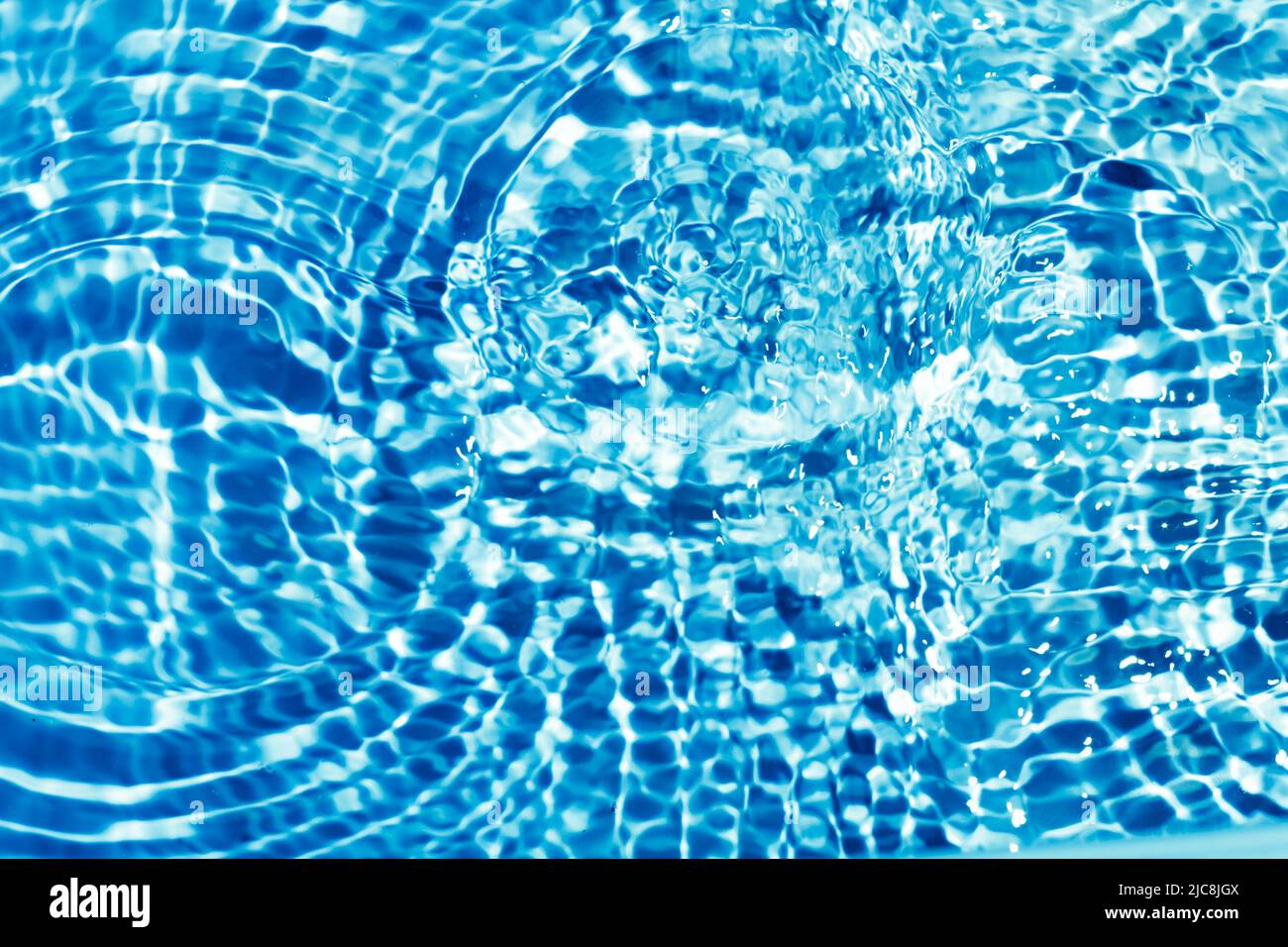 Astratto sfondo blu d'acqua con cerchi. Increspature sulla superficie dell'acqua. Foto Stock