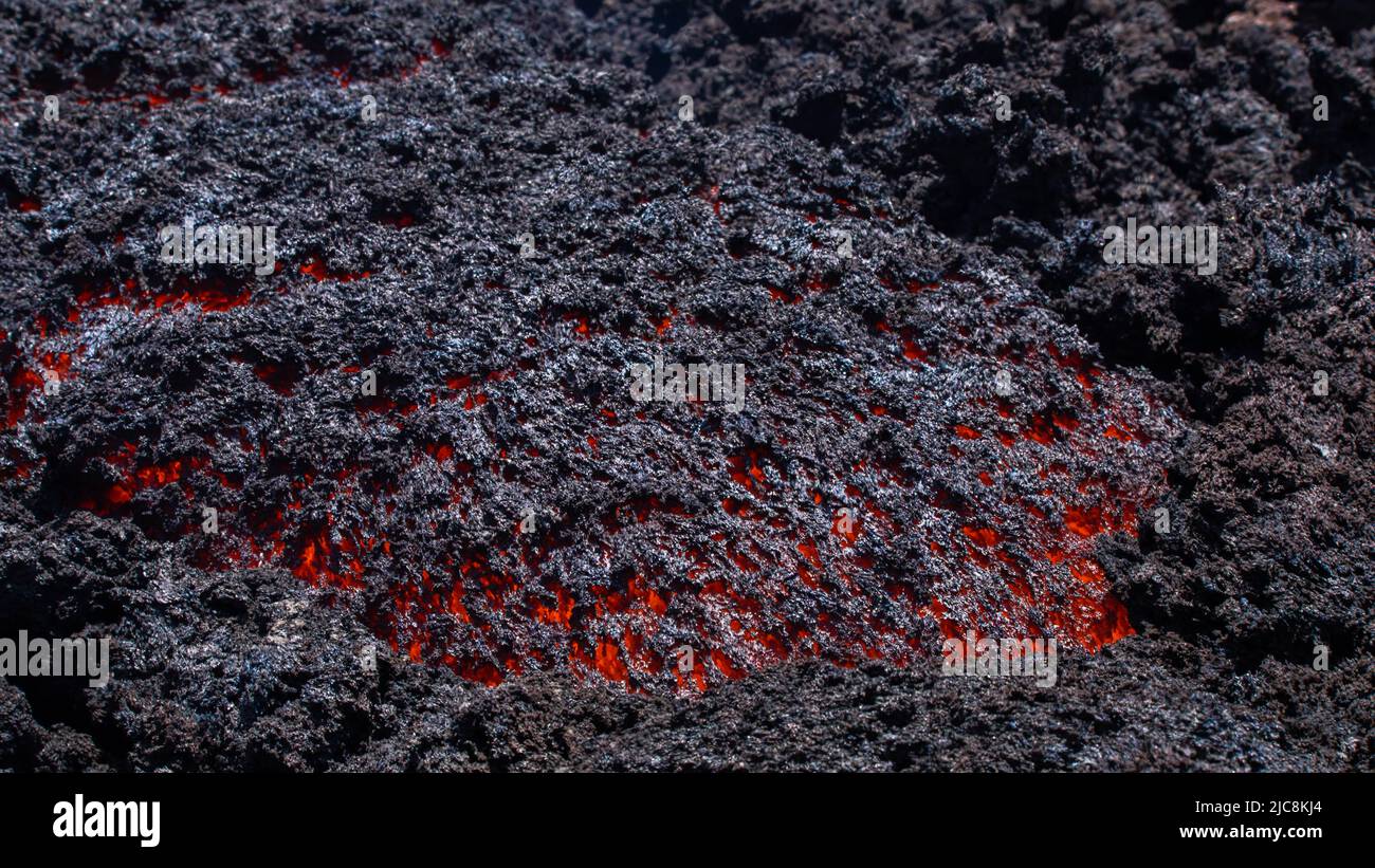 Flusso di lava incandescente sul vulcano Etna in Sicilia nella Valle del Bove con canale di fumo e flusso di lava Foto Stock