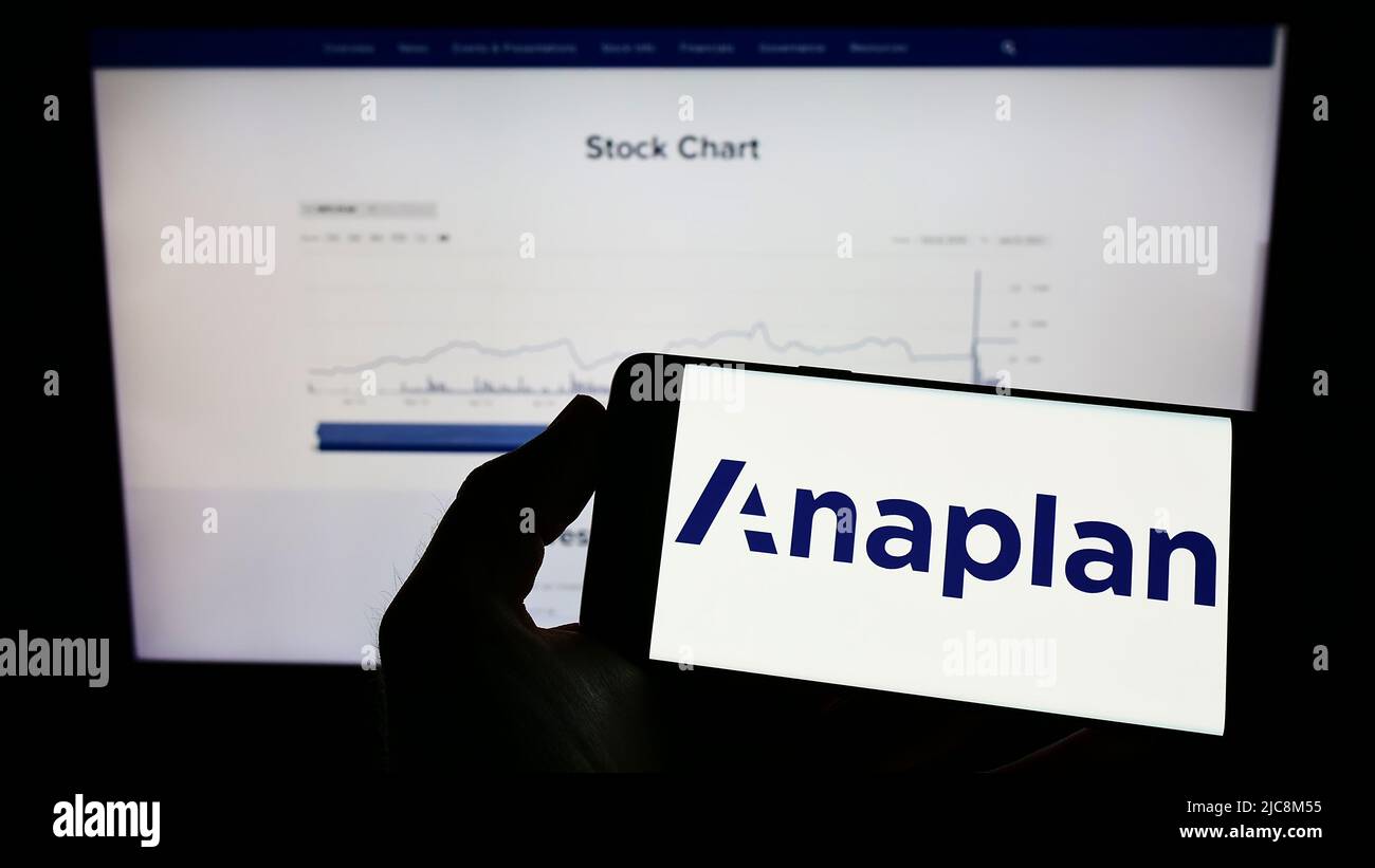 Persona che tiene il telefono cellulare con il logo della società americana di software Anaplan Inc. Sullo schermo di fronte alla pagina web aziendale. Mettere a fuoco sul display del telefono. Foto Stock