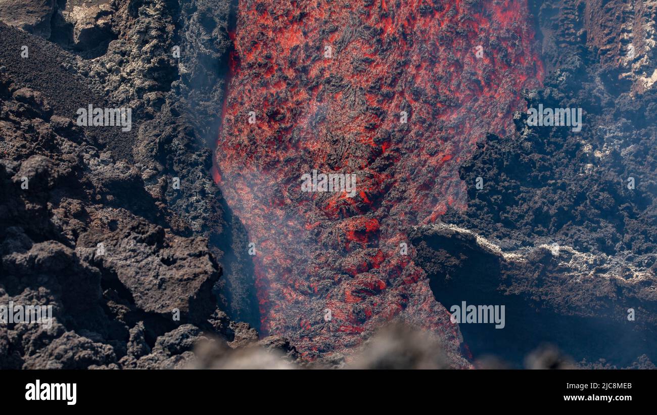 Etna colata di lava incandescente vista in dettaglio sul vulcano di Sicilia, con fumo e vapori Foto Stock