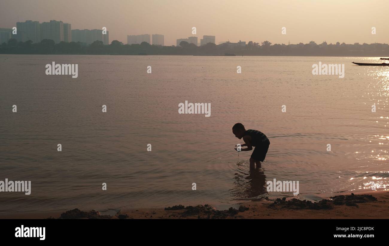 Bambini che giocano a Riverbank Sunset Vietnam Foto Stock