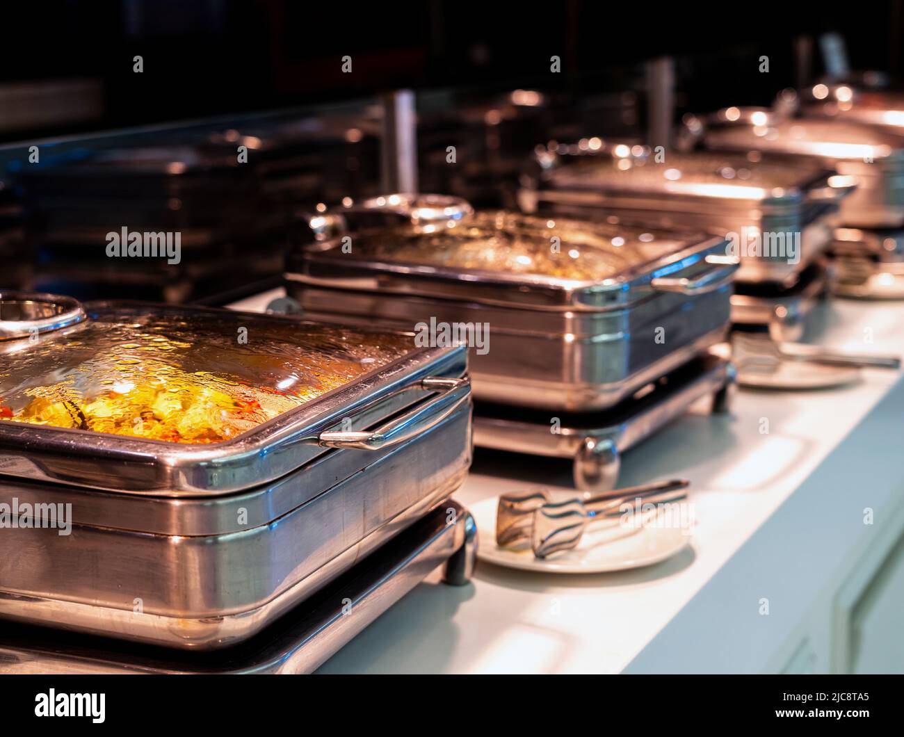 Molti piatti riscaldati a buffet sono pronti per il servizio nel ristorante dell'hotel Foto Stock