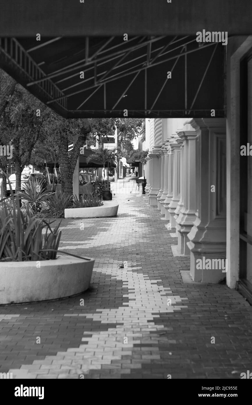Un interessante marciapiede lastricato che si snoda attraverso il centro in bianco e nero. Foto Stock