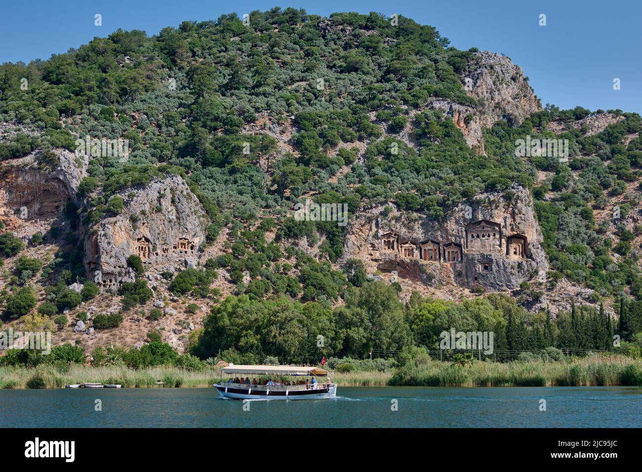 Nave turistica di fronte alle tombe di roccia Licia in una parete rocciosa di Dalyan, Turchia Foto Stock