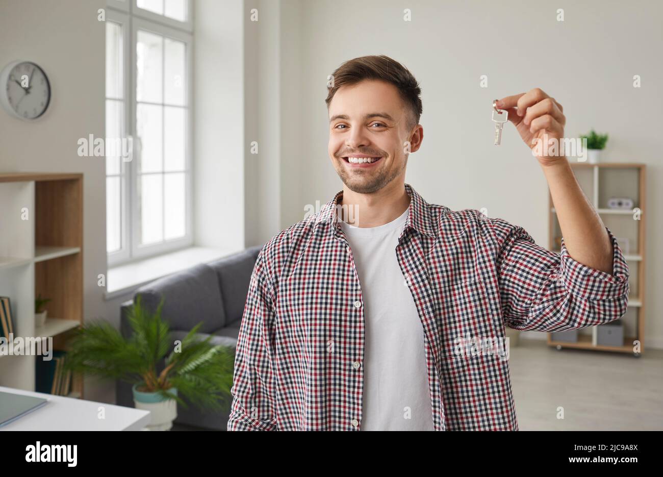 Ritratto del giovane felice sorridente e mostrando le chiavi della sua casa appena acquistata Foto Stock