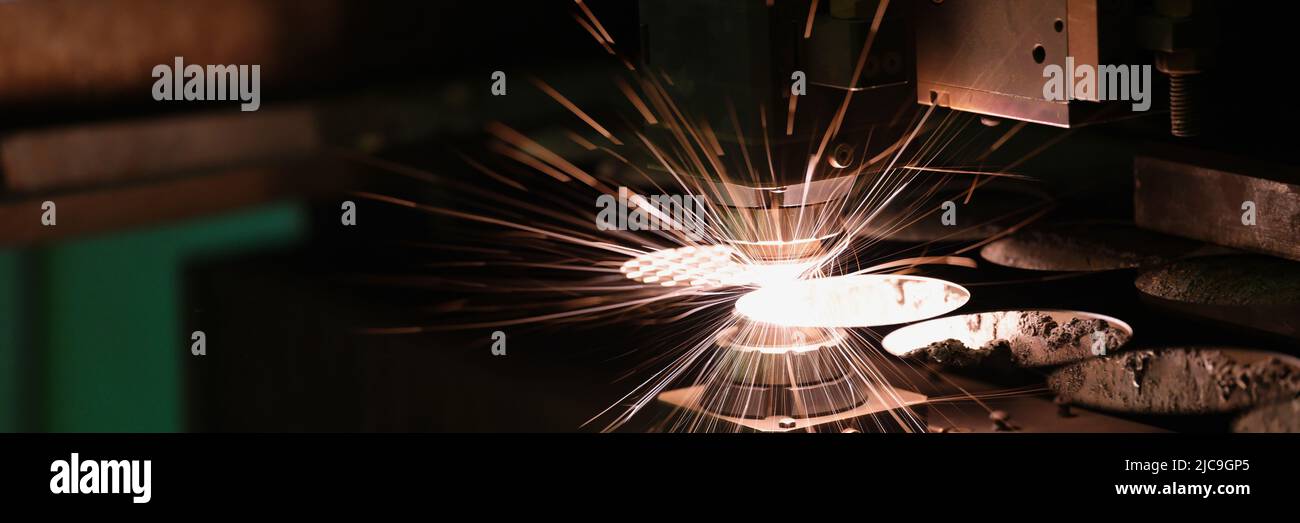 Le scintille volano fuori testa macchina per la lavorazione del metallo laser metallo Foto Stock
