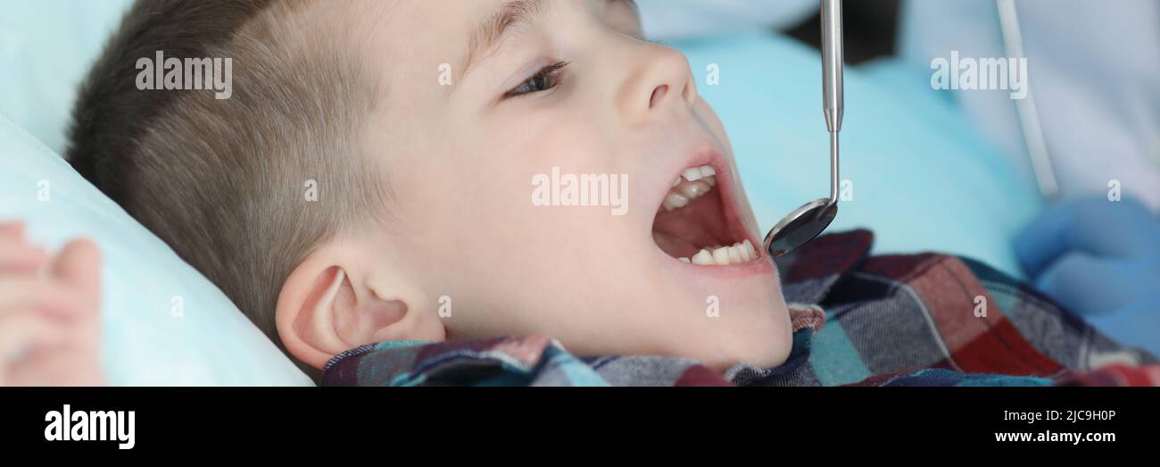 Pediatra controllare le condizioni di salute dei bambini utilizzando l'attrezzo speciale per la bocca Foto Stock