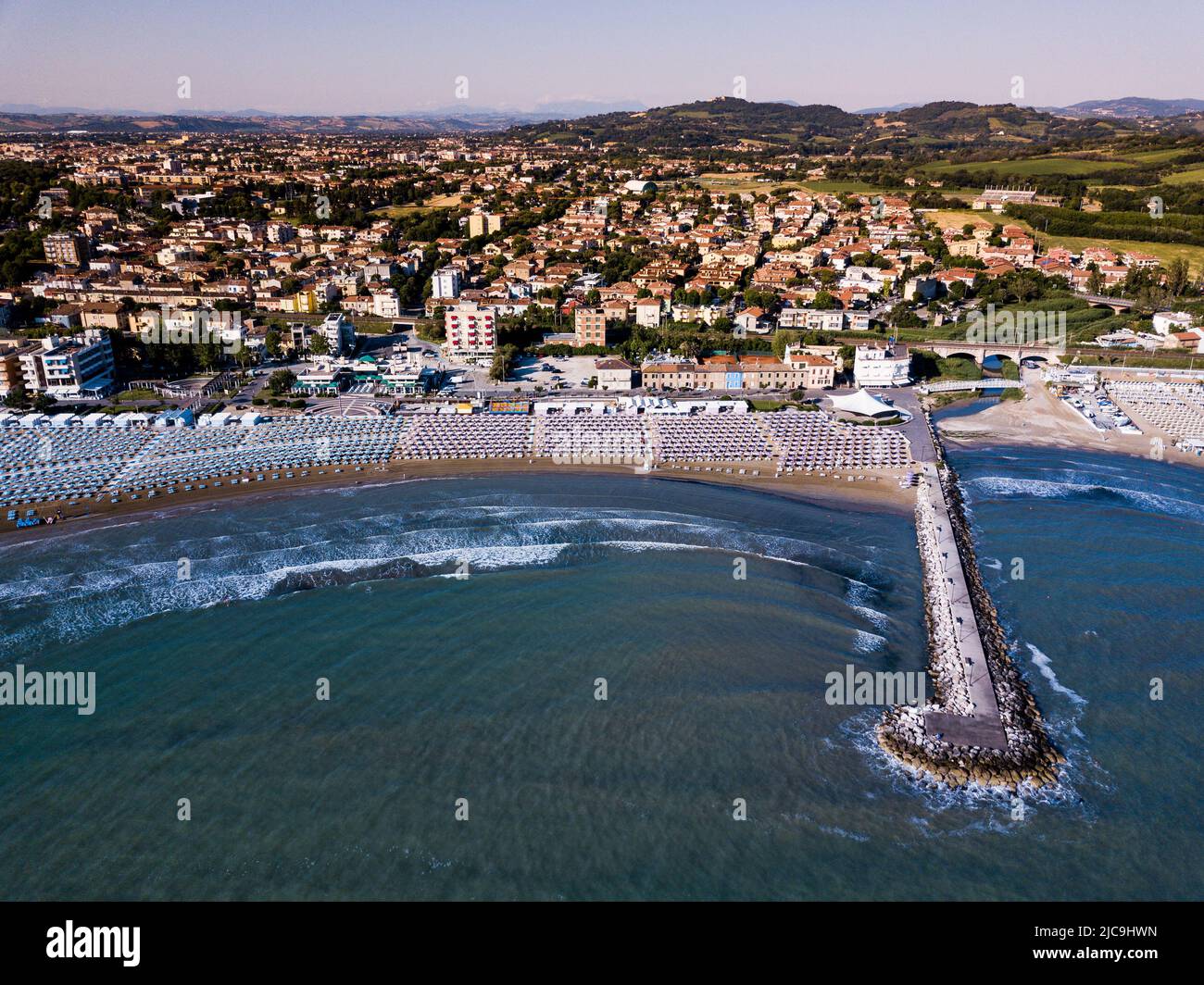 Italia, giugno 2022; veduta aerea di Fano con il suo mare, spiagge, porto, ombrelloni Foto Stock