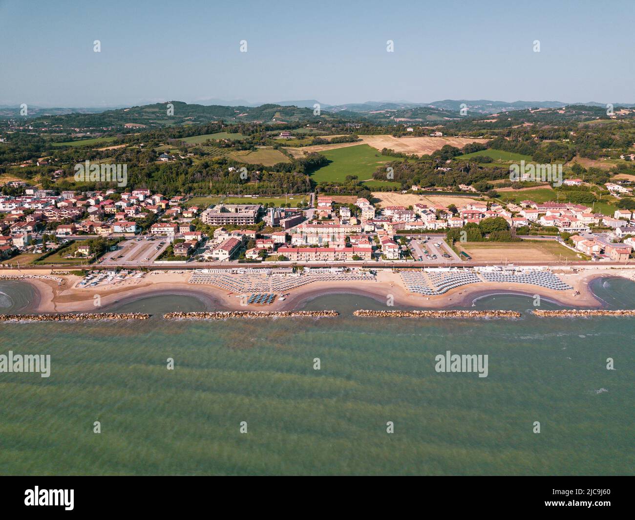 Italia, giugno 2022; veduta aerea di Fano con il suo mare, spiagge, porto, ombrelloni Foto Stock