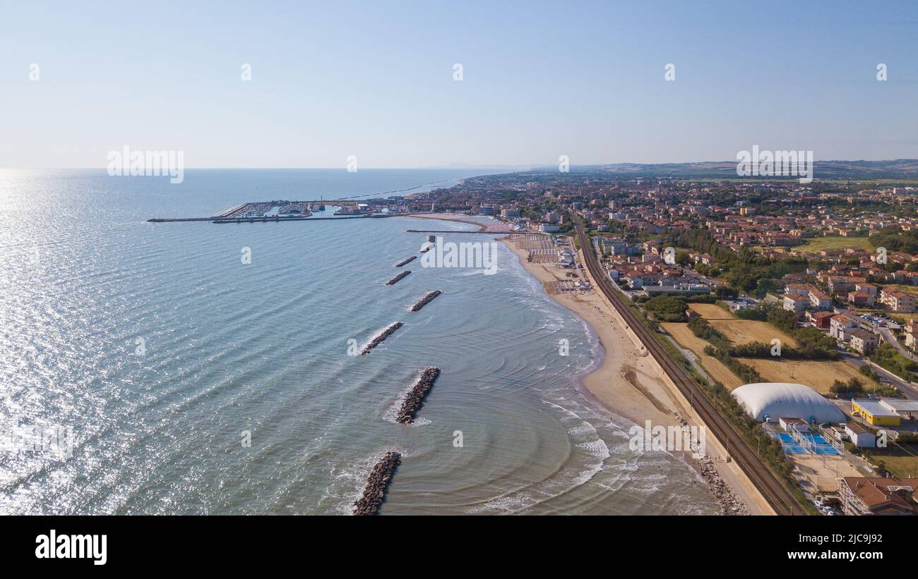Italia, giugno 2022; veduta aerea di Fano con il suo mare, spiagge, porto, ombrelloni Foto Stock