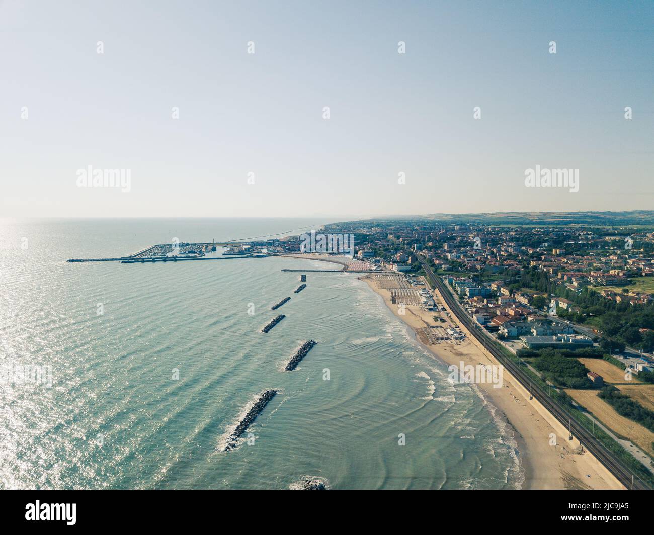Italia, giugno 2022; veduta aerea di Fano con il suo mare, spiagge, porto, ombrelloni Foto Stock
