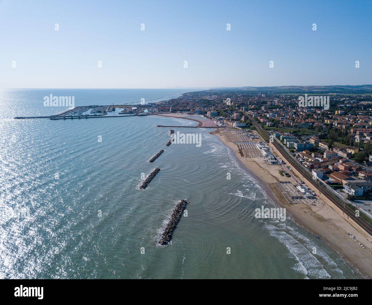 Italia, giugno 2022; veduta aerea di Fano con il suo mare, spiagge, porto, ombrelloni Foto Stock
