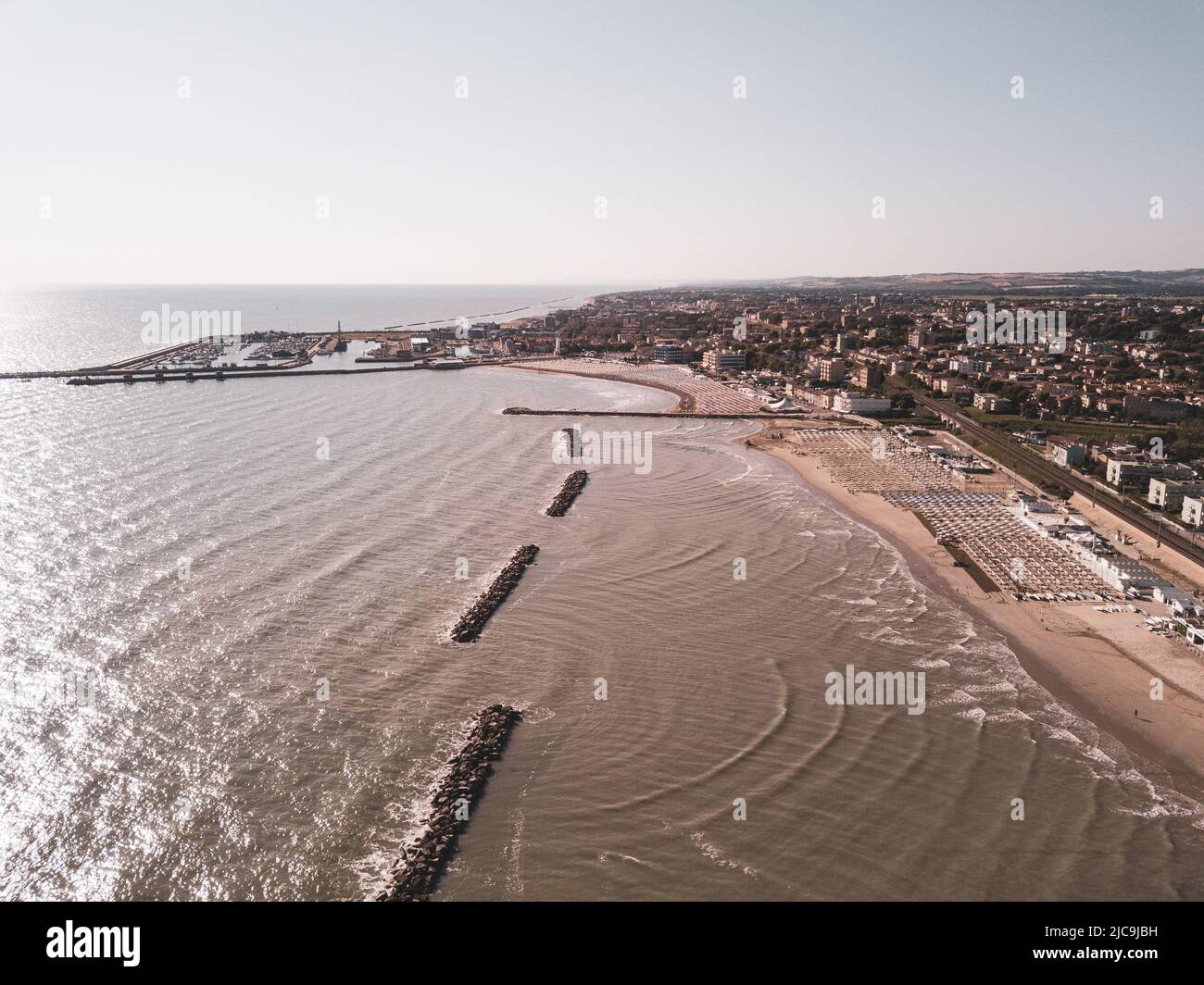 Italia, giugno 2022; veduta aerea di Fano con il suo mare, spiagge, porto, ombrelloni Foto Stock