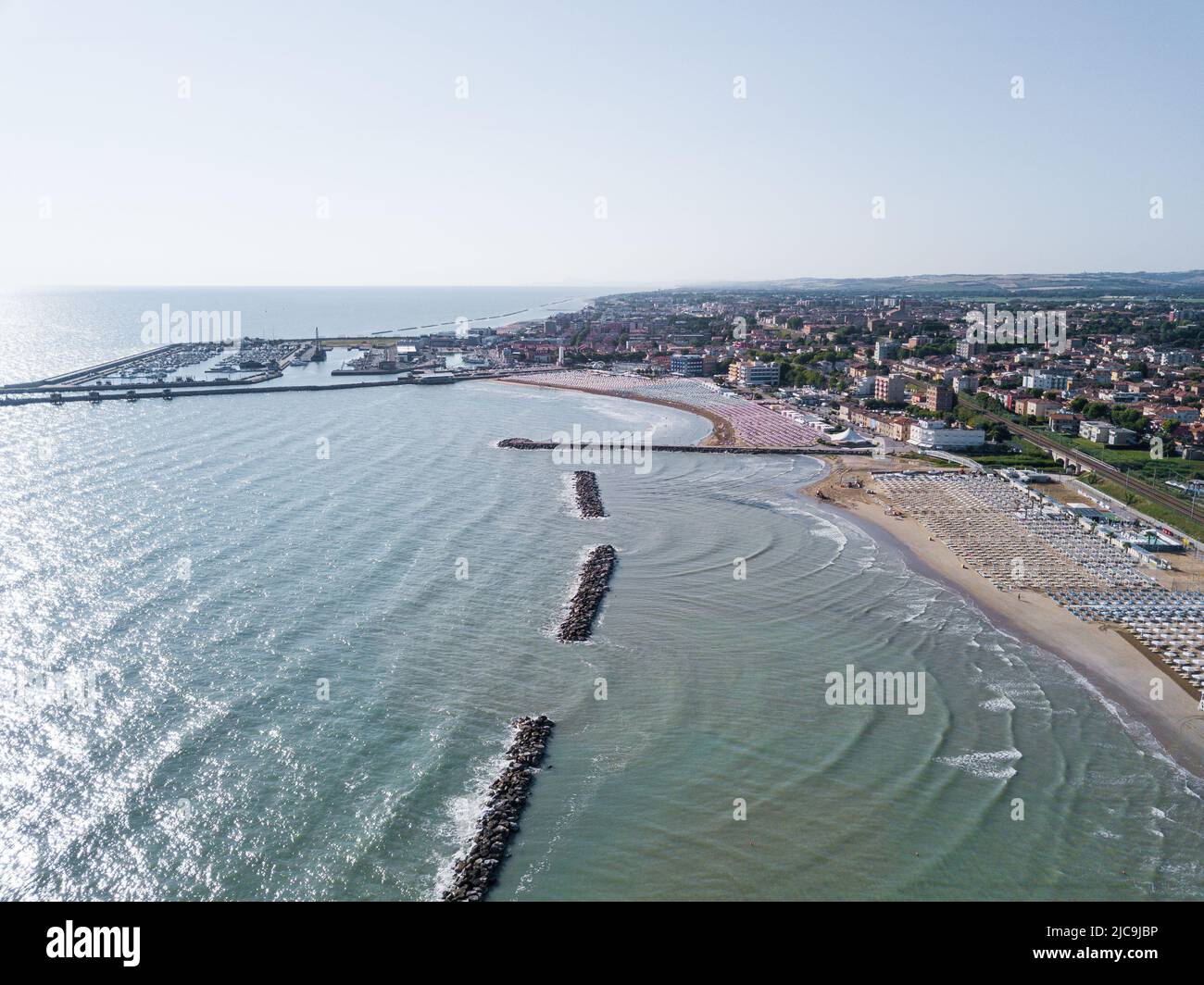 Italia, giugno 2022; veduta aerea di Fano con il suo mare, spiagge, porto, ombrelloni Foto Stock