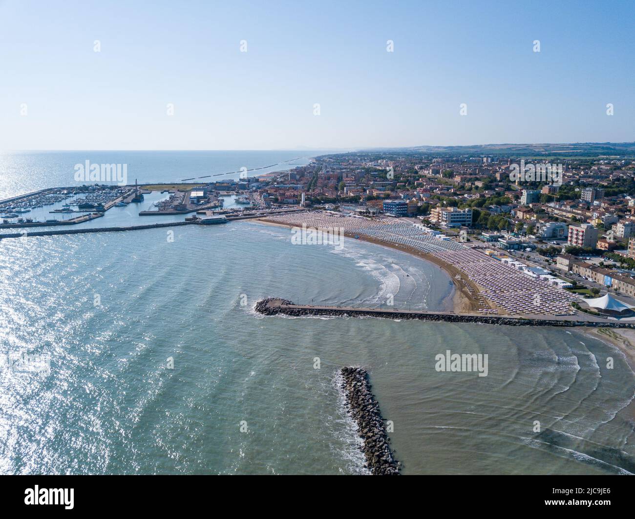 Italia, giugno 2022; veduta aerea di Fano con il suo mare, spiagge, porto, ombrelloni Foto Stock