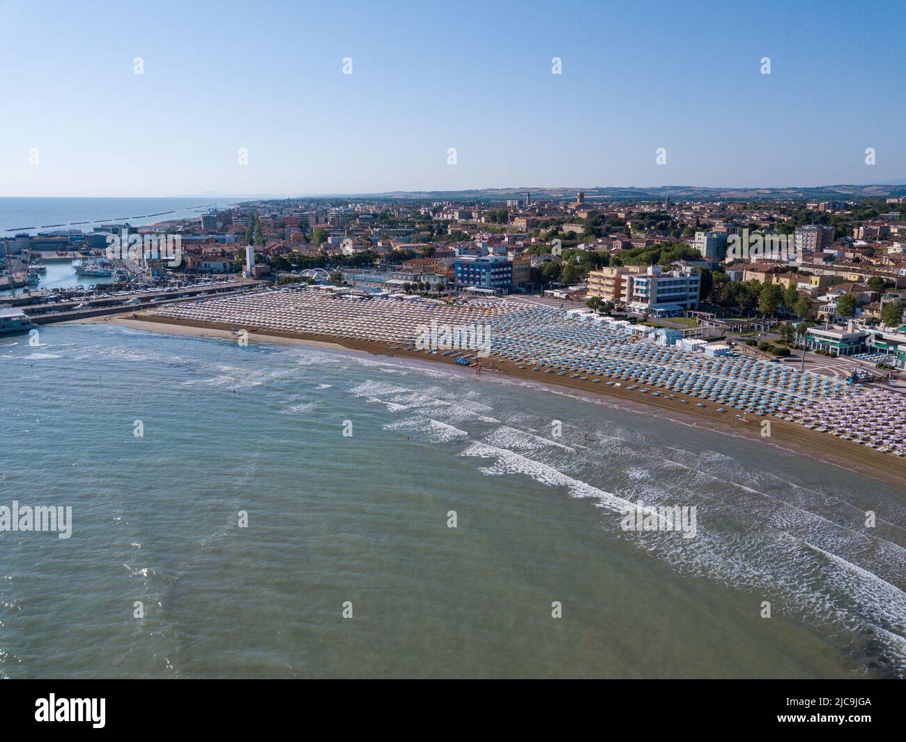 Italia, giugno 2022; veduta aerea di Fano con il suo mare, spiagge, porto, ombrelloni Foto Stock