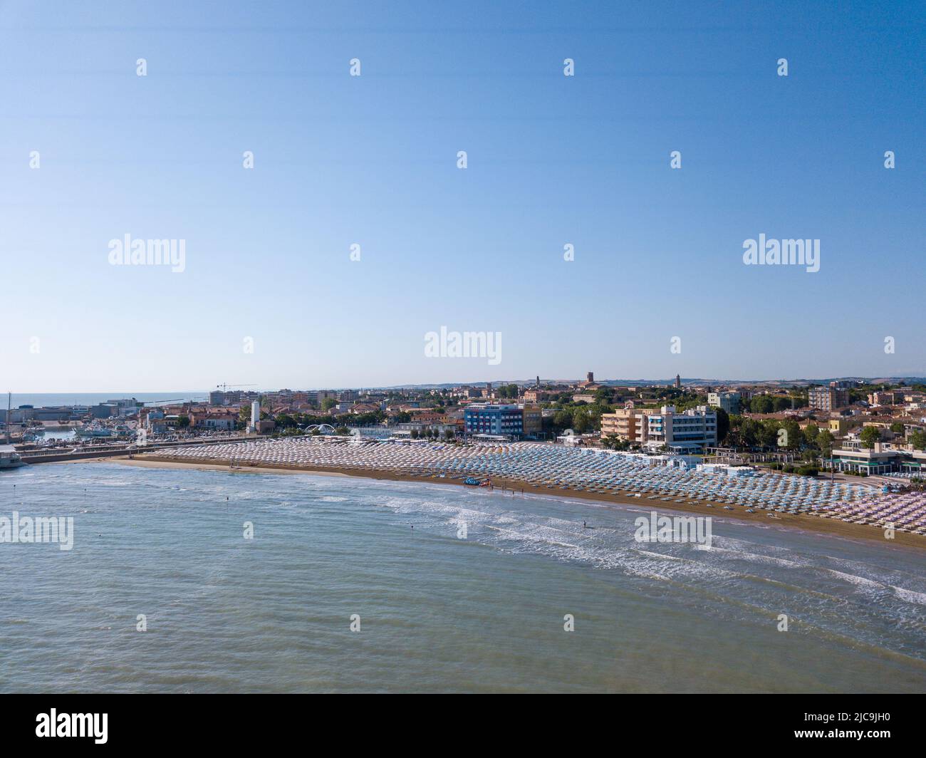 Italia, giugno 2022; veduta aerea di Fano con il suo mare, spiagge, porto, ombrelloni Foto Stock