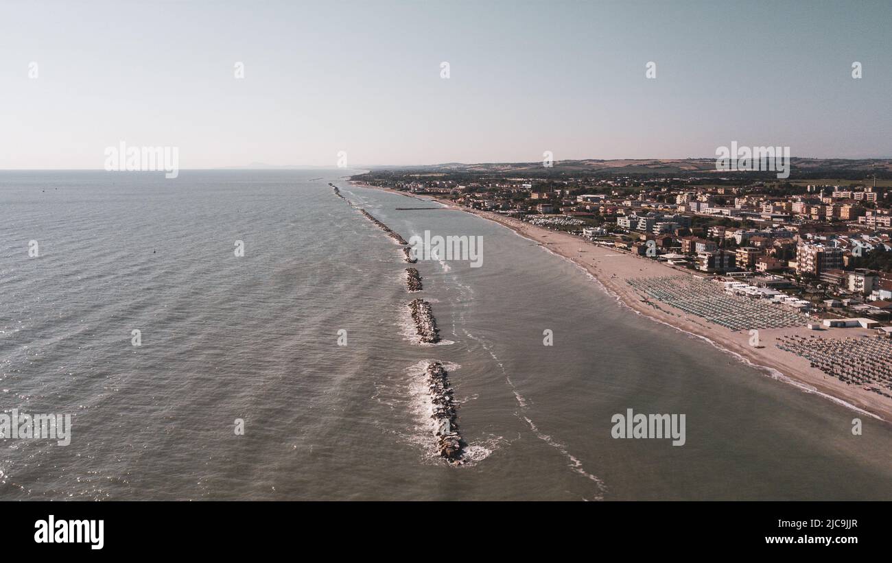 Italia, giugno 2022; veduta aerea di Fano con il suo mare, spiagge, porto, ombrelloni Foto Stock