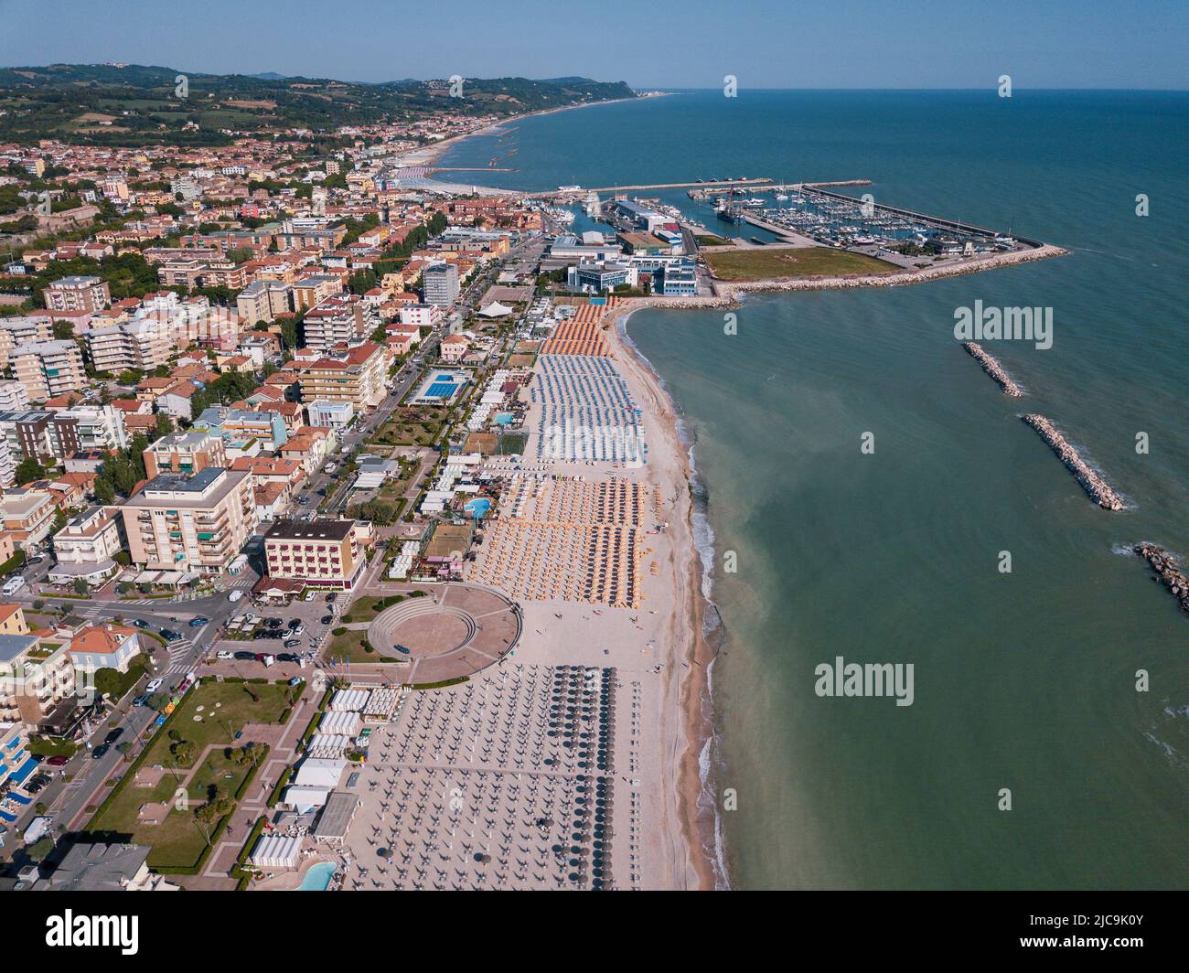 Italia, giugno 2022; veduta aerea di Fano con il suo mare, spiagge, porto, ombrelloni Foto Stock