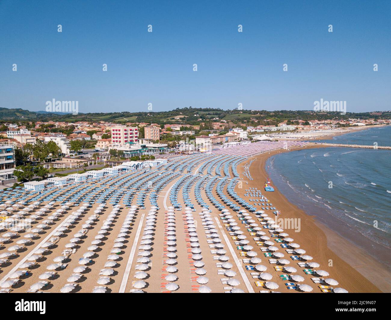 Italia, giugno 2022; veduta aerea di Fano con il suo mare, spiagge, porto, ombrelloni Foto Stock