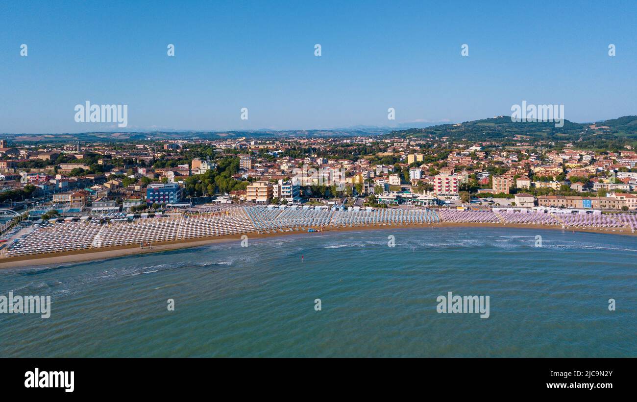 Italia, giugno 2022; veduta aerea di Fano con il suo mare, spiagge, porto, ombrelloni Foto Stock