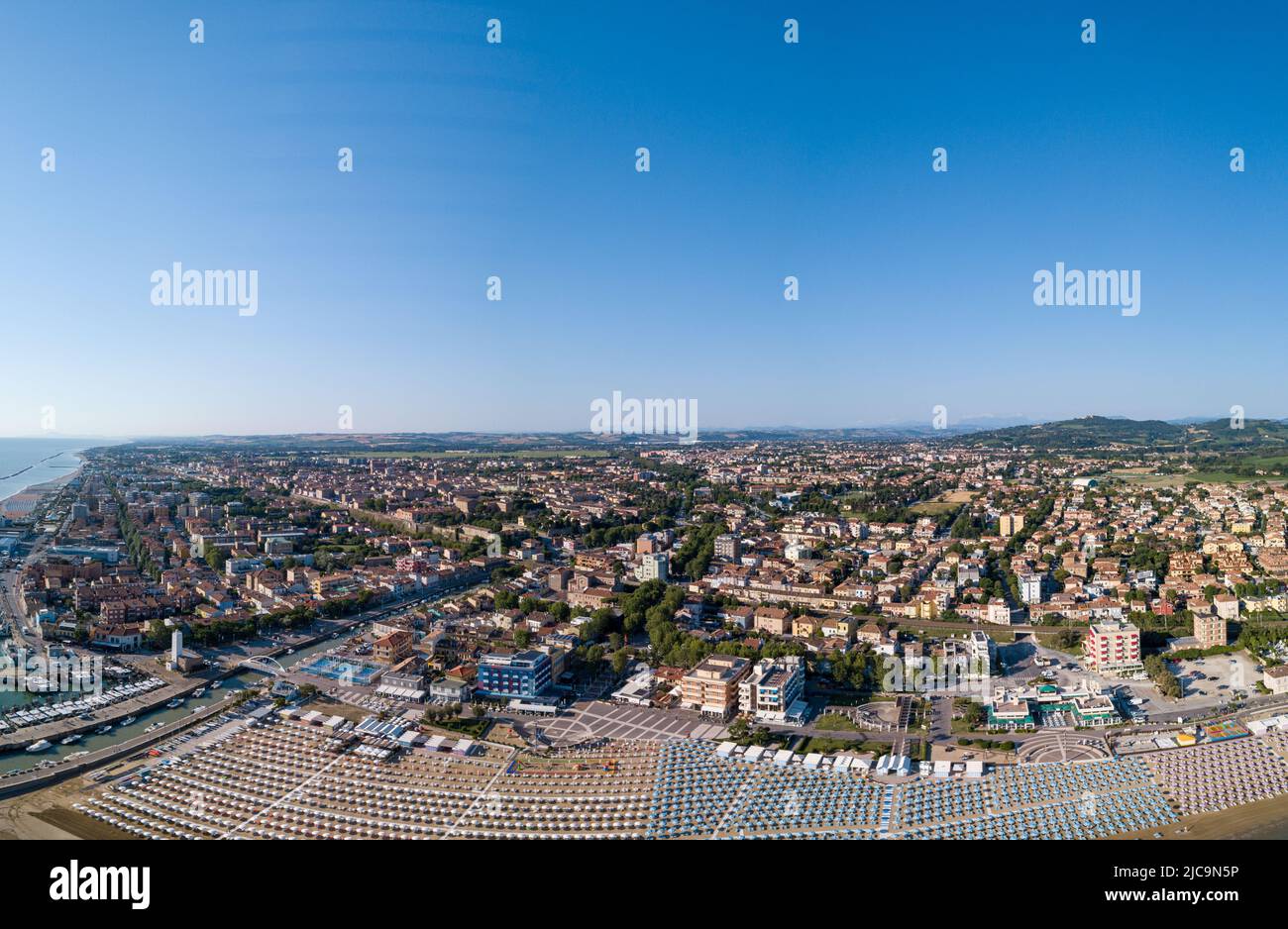 Italia, giugno 2022; veduta aerea di Fano con il suo mare, spiagge, porto, ombrelloni Foto Stock