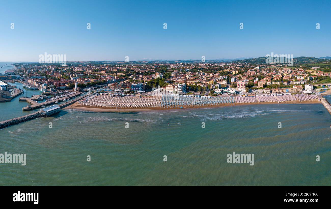 Italia, giugno 2022; veduta aerea di Fano con il suo mare, spiagge, porto, ombrelloni Foto Stock