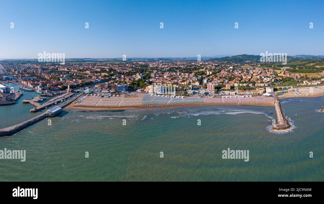 Italia, giugno 2022; veduta aerea di Fano con il suo mare, spiagge, porto, ombrelloni Foto Stock