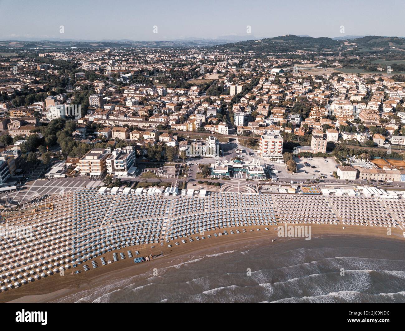 Italia, giugno 2022; veduta aerea di Fano con il suo mare, spiagge, porto, ombrelloni Foto Stock