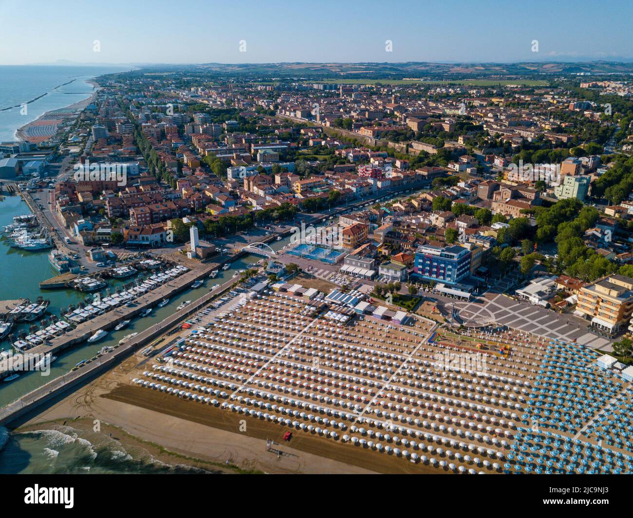 Italia, giugno 2022; veduta aerea di Fano con il suo mare, spiagge, porto, ombrelloni Foto Stock