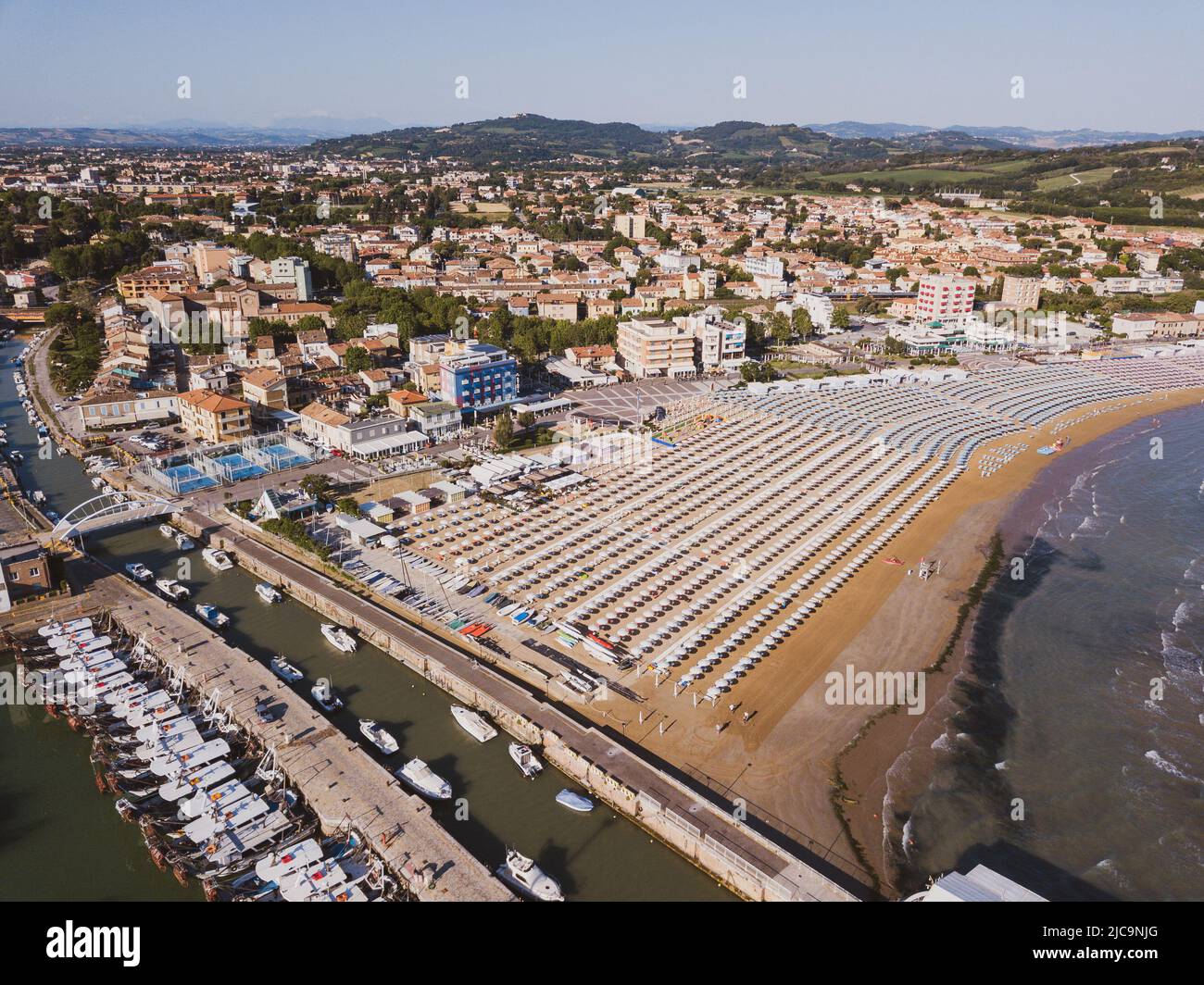 Italia, giugno 2022; veduta aerea di Fano con il suo mare, spiagge, porto, ombrelloni Foto Stock
