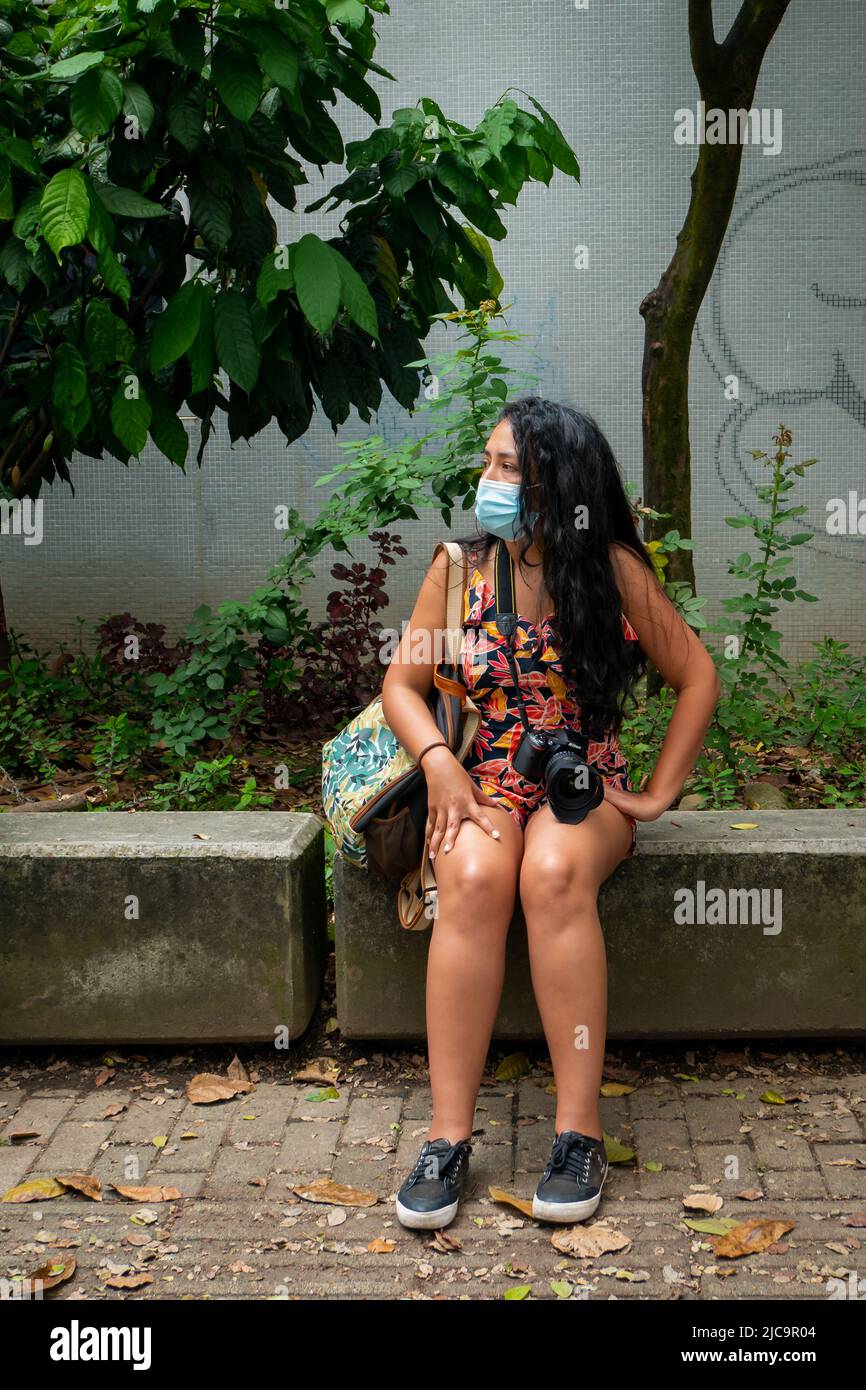 Medellin, Antioquia, Colombia - Febbraio 19 2022: Donna colombiana con capelli neri lunghi tiene la sua macchina fotografica ad una Convenzione fotografica Foto Stock