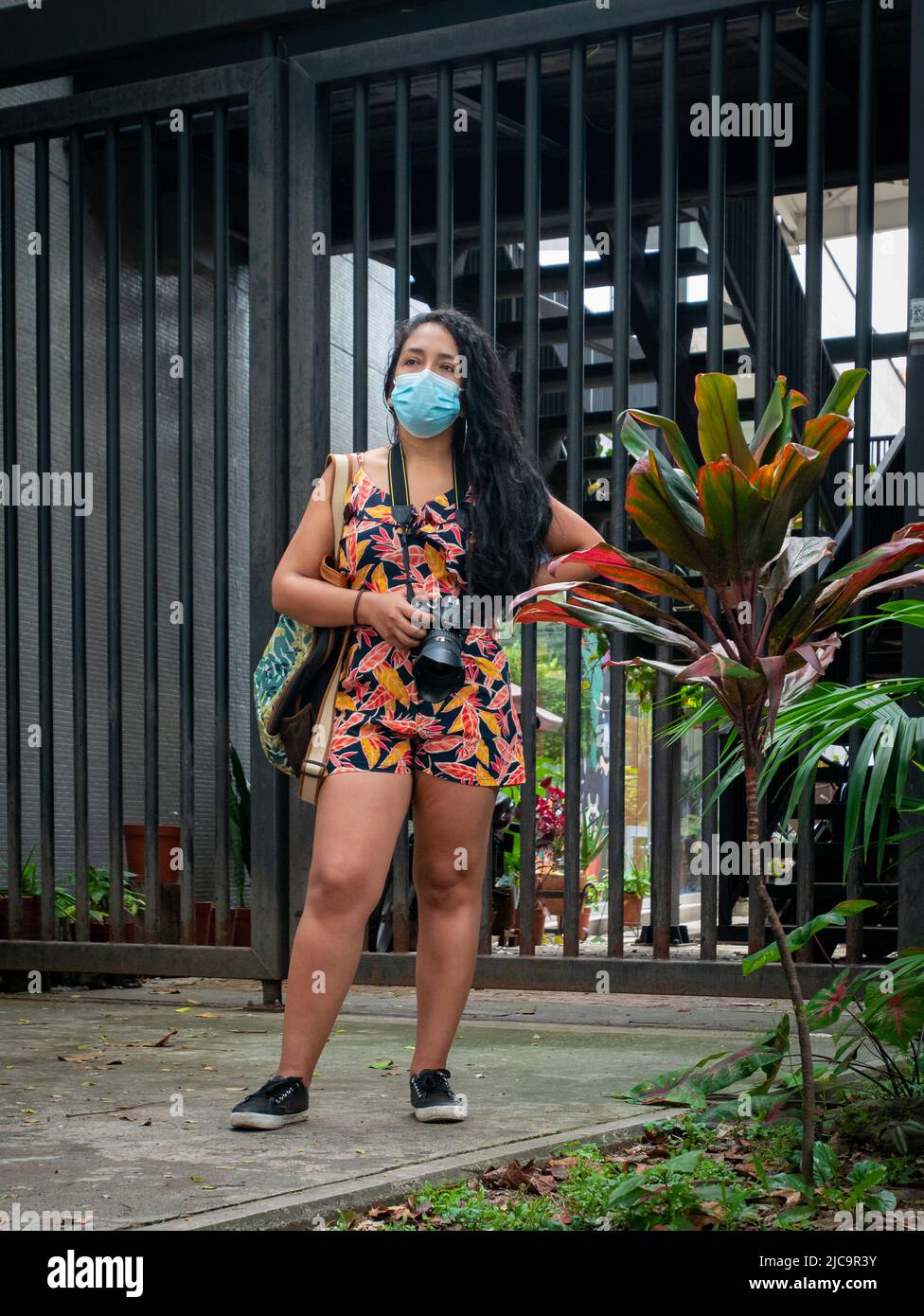 Medellin, Antioquia, Colombia - Febbraio 19 2022: Donna colombiana con capelli neri lunghi tiene la sua macchina fotografica ad una Convenzione fotografica Foto Stock