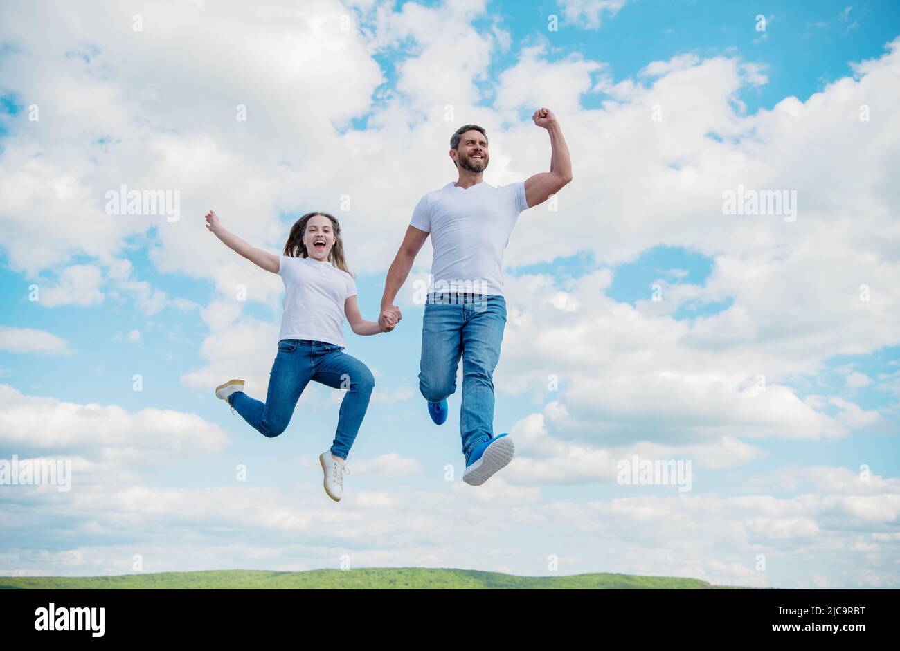 felice padre e figlia saltano in cielo. sostegno della famiglia Foto Stock