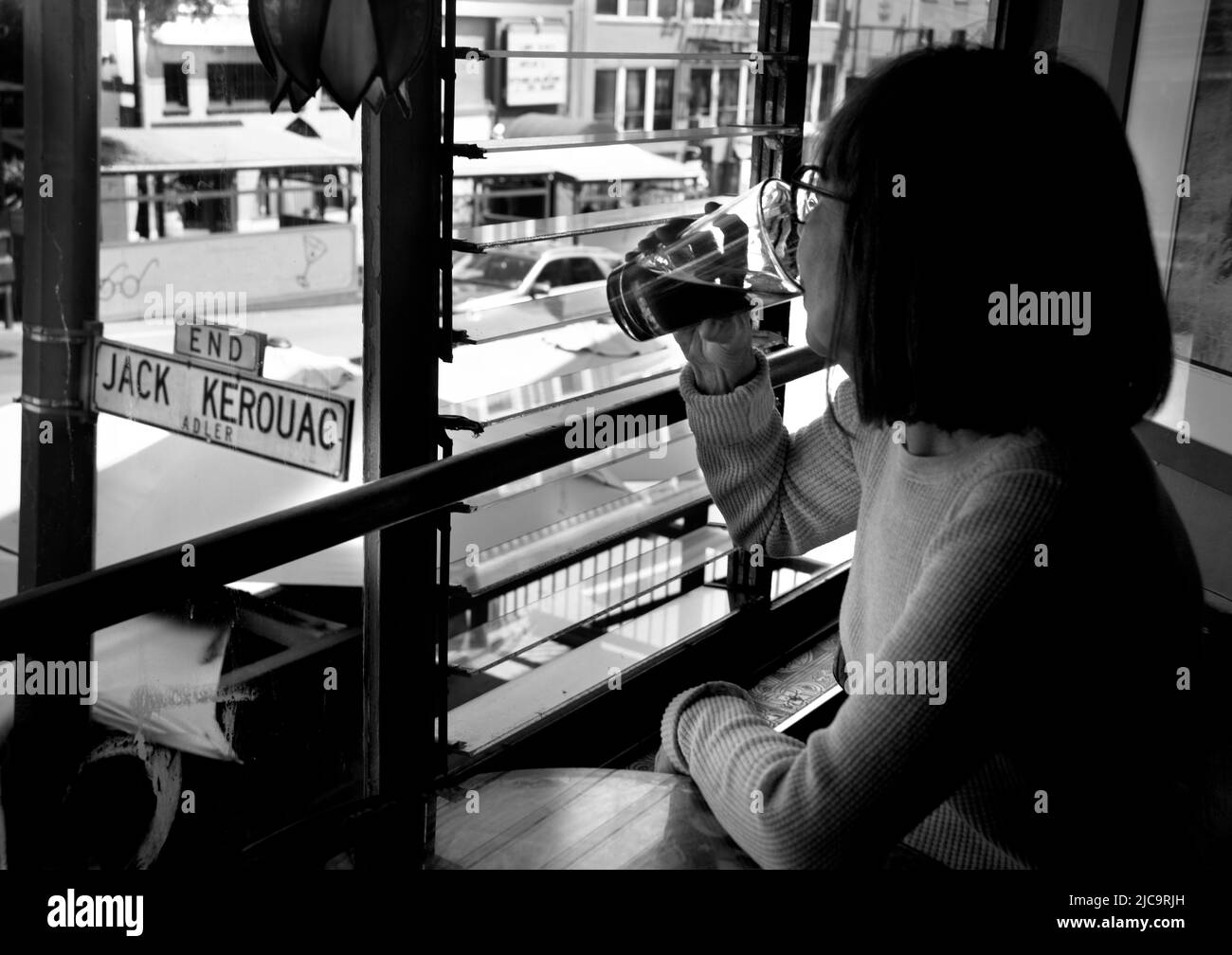 Una donna gode di una pinta di birra al Vesuvio Cafe, un punto di riferimento a San Francisco, California, frequentato dai membri della Beat Generation 1950s. Foto Stock