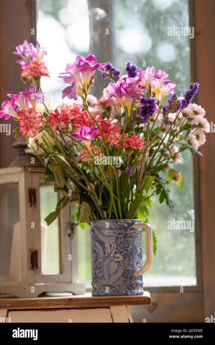 caraffa blu di colorati fiori estivi Foto Stock
