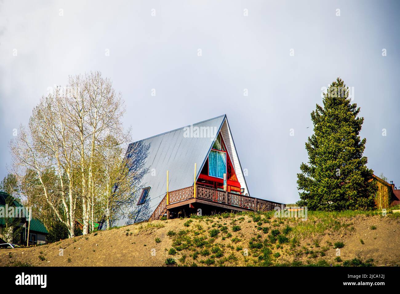 Aframe casa in cima alla collina con gli alberi di aspen e sempreverdi nel villaggio di stazione sciistica in Colorado Stati Uniti Foto Stock