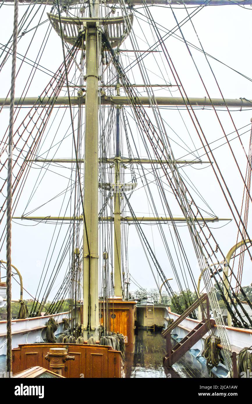 Primo piano dell'armamento di un'alta nave a vela in legno con un ponte di legno lucido bagnato contro il cielo coperto Foto Stock Primo piano dell'armamento di un'alta nave a vela in legno con un ponte di legno lucido bagnato contro il cielo coperto Foto Stock