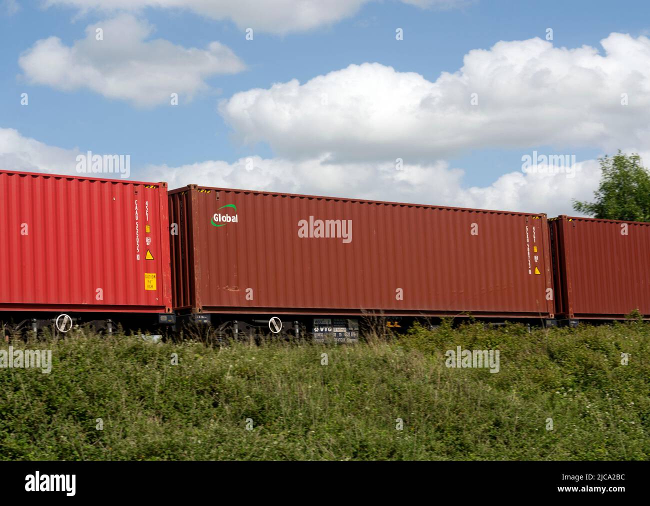 Container di spedizione globale su un treno freightliner, Warwickshire, Regno Unito Foto Stock