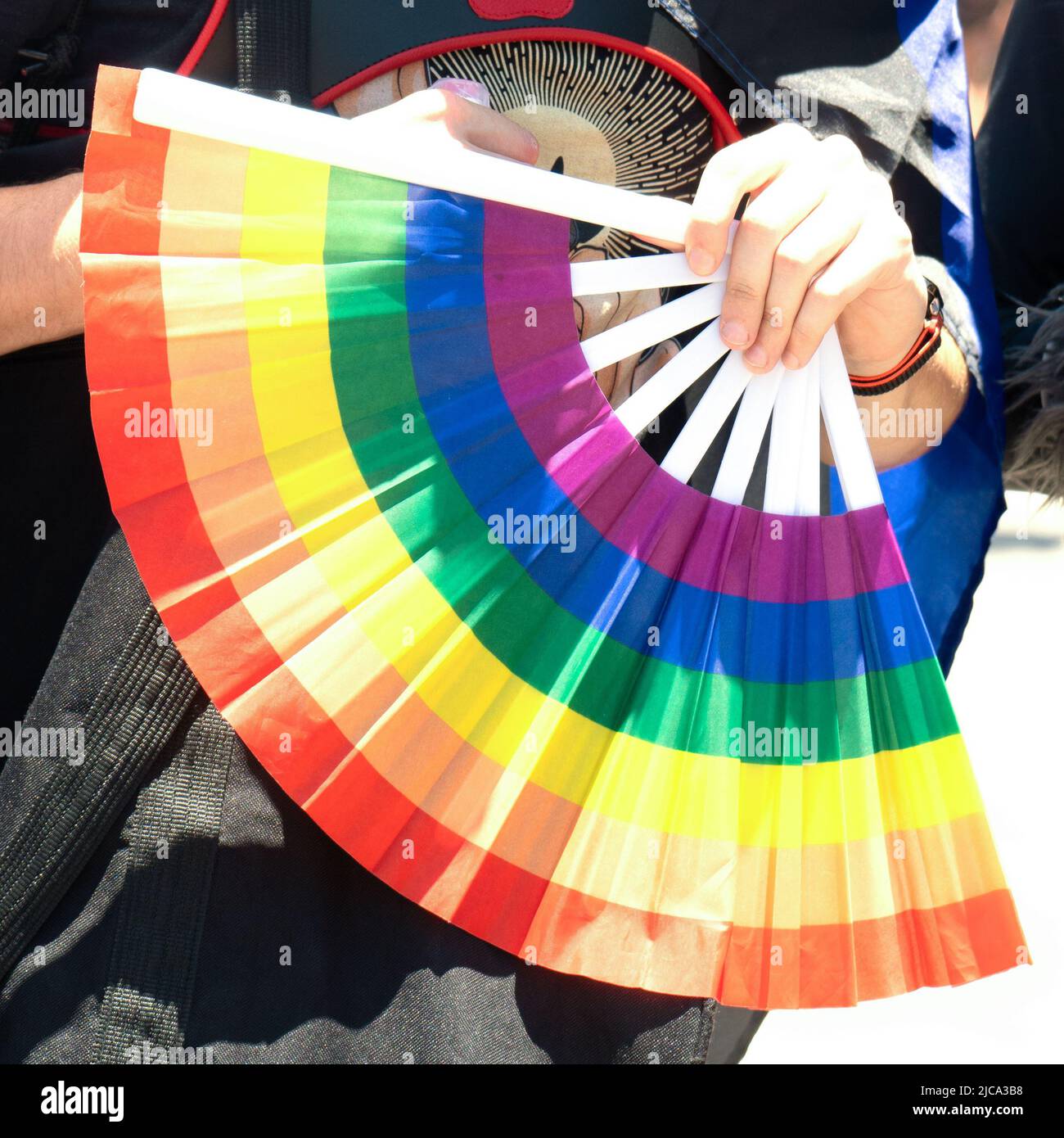 Tel Aviv Yafo, Israele - 10 giugno 2022. Mano che tiene un fan dei colori arcobaleno lgbt primo piano Foto Stock