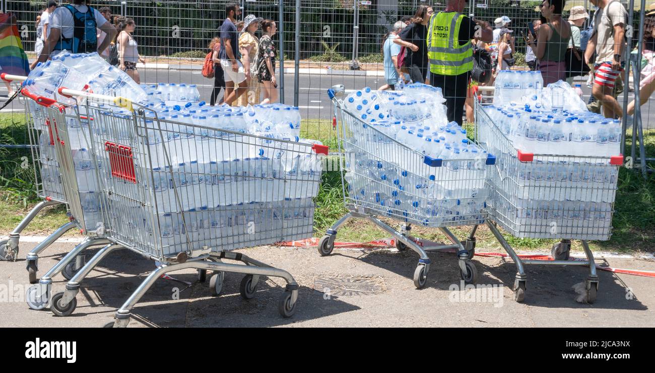 Tel Aviv Yafo, Israele - 10 giugno 2022. Shopping cart pieno di bottiglie di acqua stand all'aperto in caldo sole tempo Foto Stock