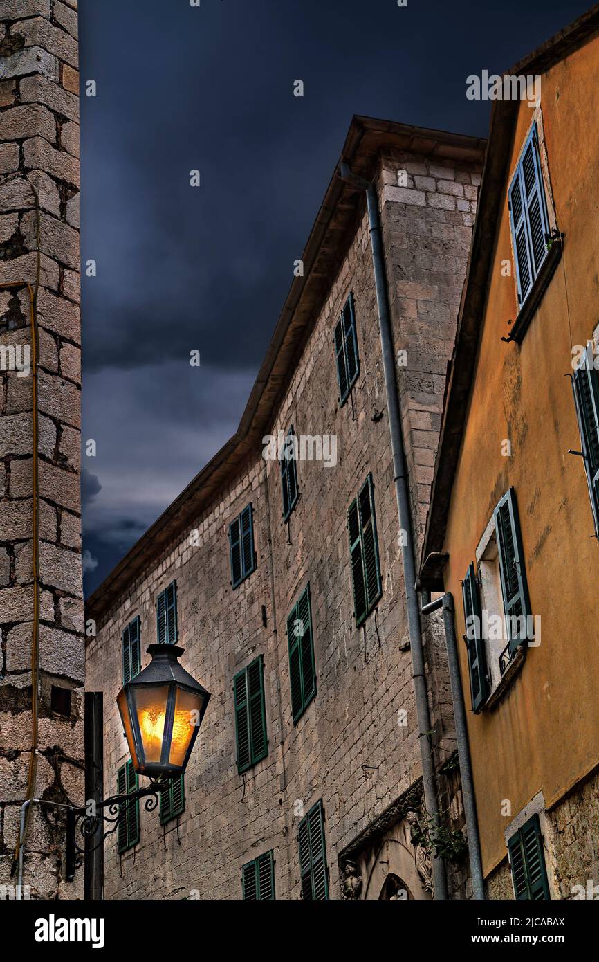 Vecchie case e luci di strada nella città vecchia Kotor, Montenegro Foto Stock