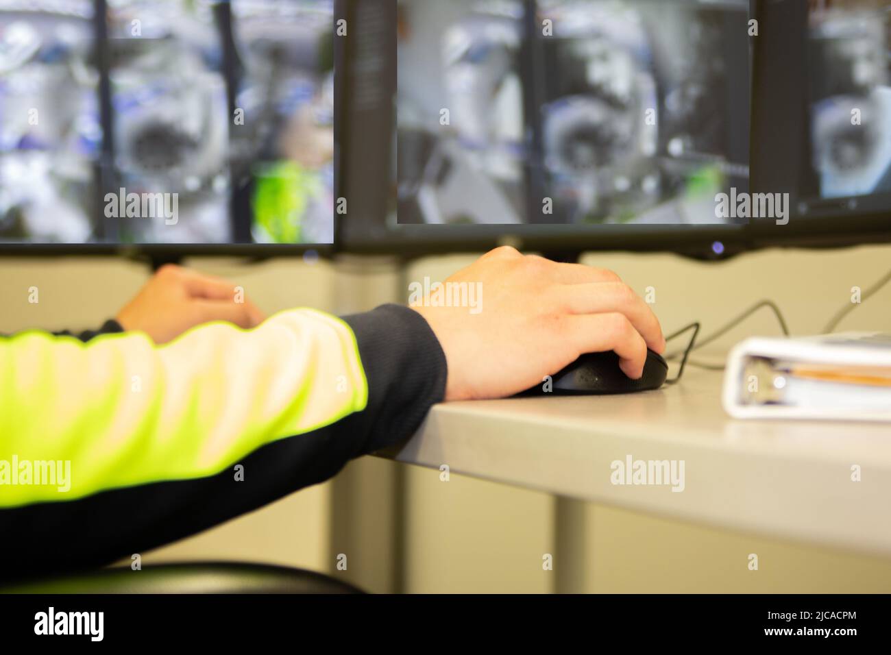 Il team addetto alla sicurezza guarda i monitor di sorveglianza TVCC. Foto Stock