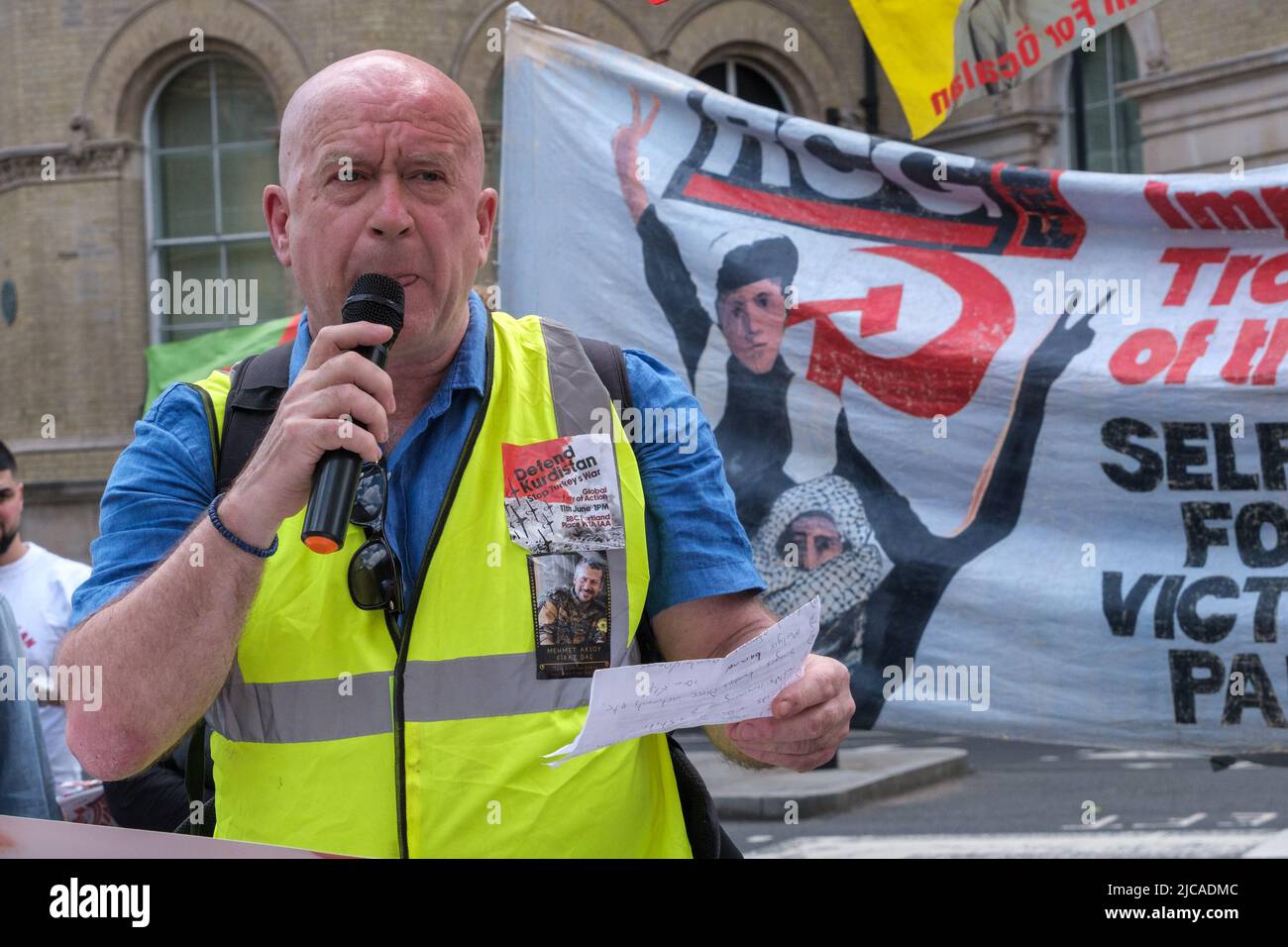 Londra, Regno Unito. 11 giugno 2022. Mark Campbell introduce i relatori prima che i sostenitori della campagna elettorale portino a marcia Londra contro la nuova e mortale invasione turca delle aree curde in Iraq e Siria, iniziata in aprile, chiedendo la fine delle vendite di armi nel Regno Unito. La Turchia ha costruito diverse basi militari in Iraq e occupato grandi aree in Siria con l'aiuto di ex militanti dell'Isis e utilizzando attacchi aerei e armi chimiche vietate. La Turchia e l’Occidente mirano a distruggere la visione curda di un Medio Oriente decentralizzato, democratico ed egualitario. Peter Marshall / Alamy Live News Foto Stock